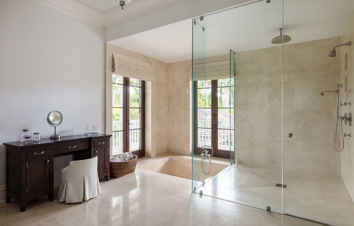 Así es la propiedad de Pharrell Williams en Coral Gables, Miami. Destacan los cuartos de baños con suelos de mármol, amplias duchas de vidrio transparente y bañeras de baja construcción. Los tocadores de madera ponen el toque de elegancia a estos espacios.
