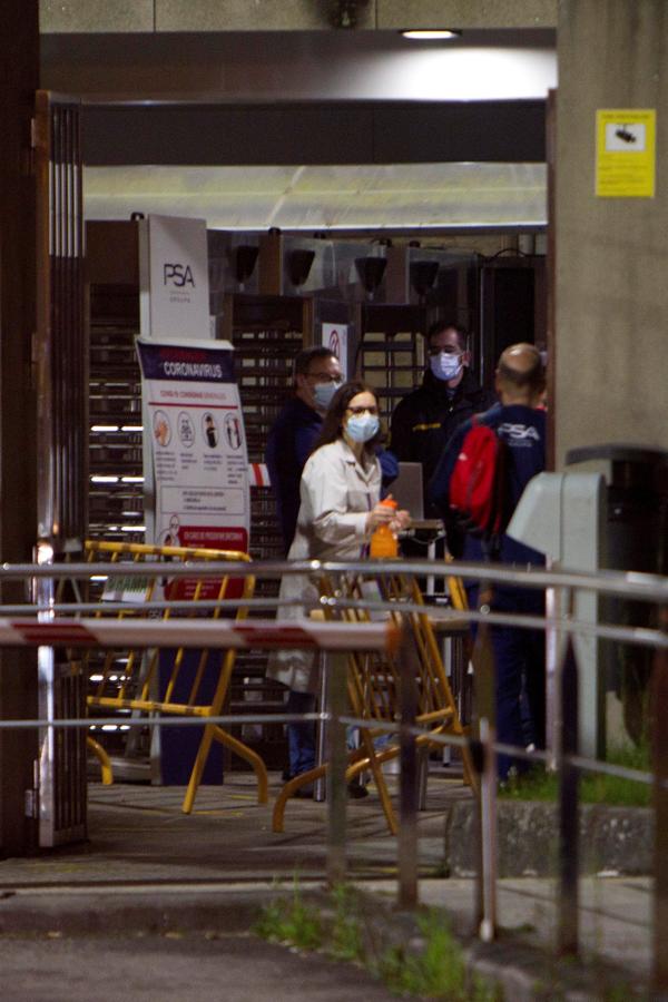 El sector de la automoción reanuda su actividad. Los trabajadores de las plantas PSA de Vigo y de Zaragoza han vuelto hoy a las instalaciones para reanudar la producción a partir de este miércoles. Se han modificado los turnos para que no se produzcan aglomeraciones. En la imagen, una empleada con mascarilla ofrece gel desinfectante a un compañero en la factoría viguesa