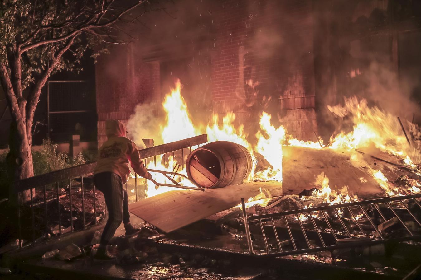 Disturbios en Mineápolis. Un manifestante alimenta las llamas durante las protestas en Mineápolis