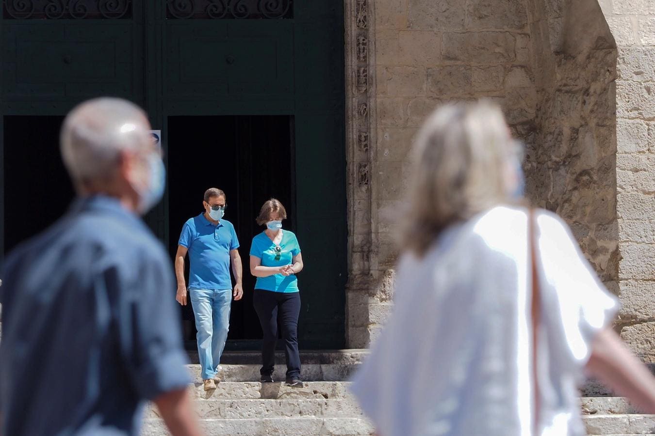 De vuelta a la rutina de ir a misa. Una pareja con mascarillas sale de  mias de la Iglesia de San Benito de Valladolid