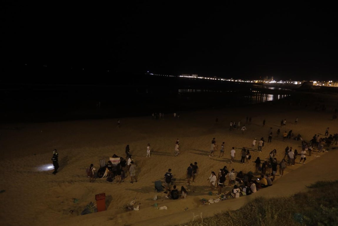 FOTOS: Unos 1.000 jóvenes son desalojados de la playa en Cádiz cuando hacían botellón por San Juan