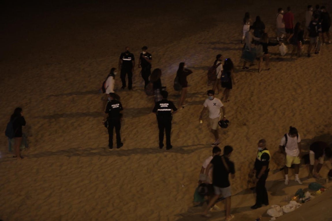FOTOS: Unos 1.000 jóvenes son desalojados de la playa en Cádiz cuando hacían botellón por San Juan