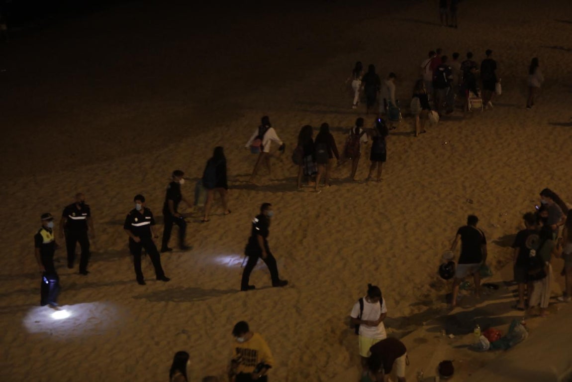 FOTOS: Unos 1.000 jóvenes son desalojados de la playa en Cádiz cuando hacían botellón por San Juan