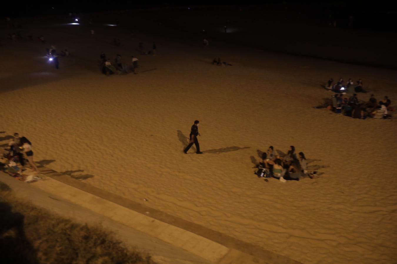 FOTOS: Unos 1.000 jóvenes son desalojados de la playa en Cádiz cuando hacían botellón por San Juan