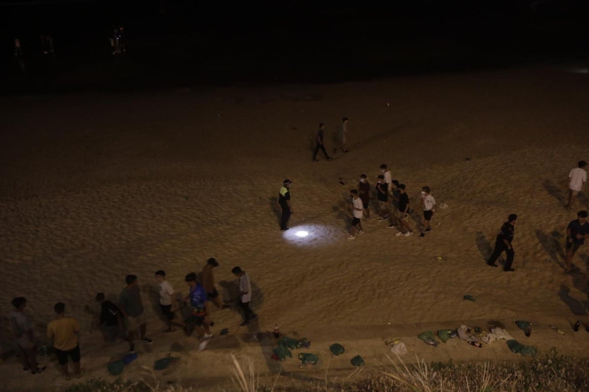 FOTOS: Unos 1.000 jóvenes son desalojados de la playa en Cádiz cuando hacían botellón por San Juan