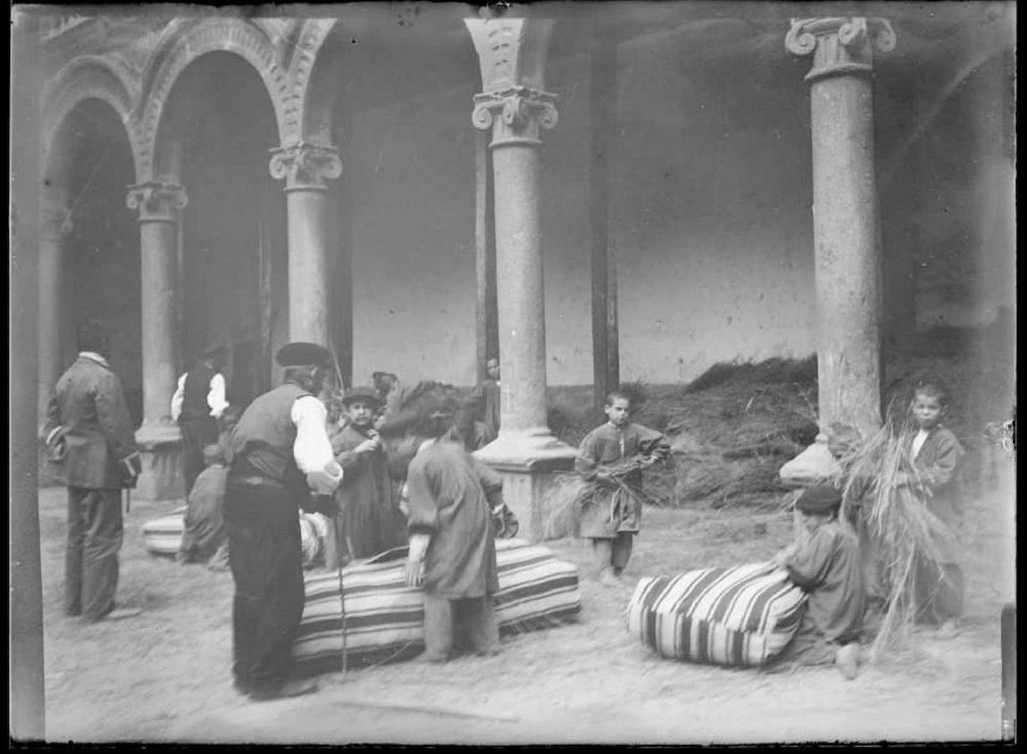 Niños rellenado colchones de paja, a principios del siglo XX, en el patio de San Pedro Mártir, sede del Asilo Provincial. Archivo Municipal de Toledo. Fotografía del fondo de Santiago Relanzón. 