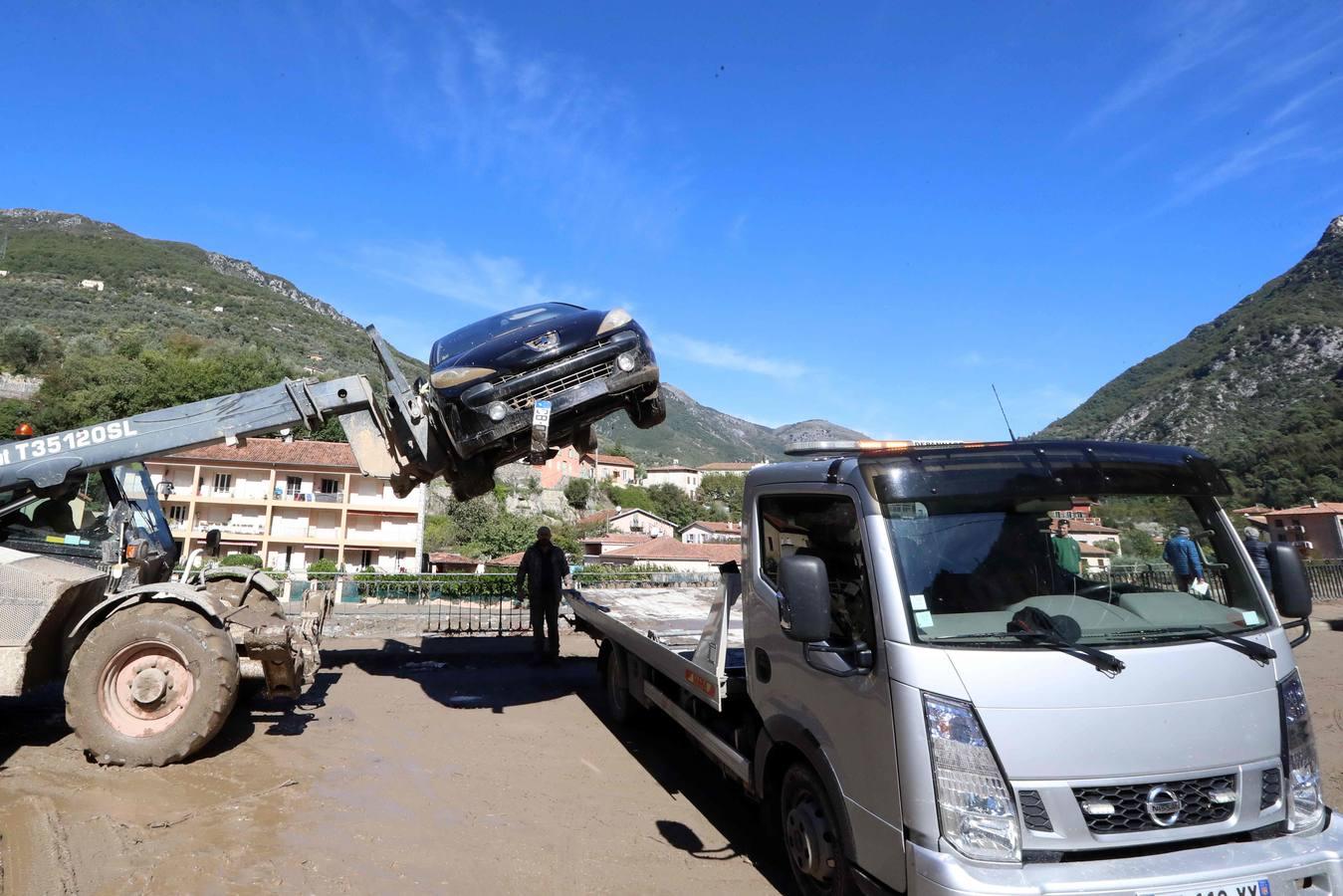 Una grúa aparta un coche destrozado por la fuerza de la tormenta Alex. 