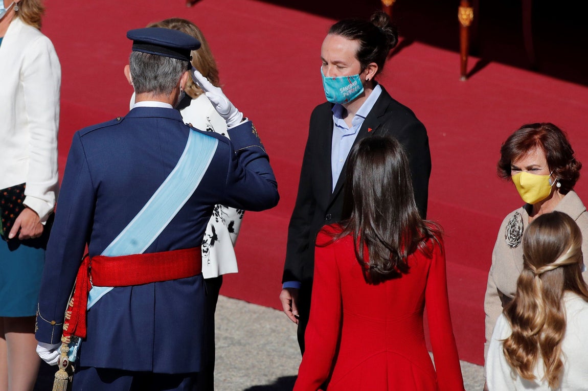 Iglesias baja la vista al ser saludado por Don Felipe. Es otra de las imágenes de la celebración del 12-O. La primera vez que veían "frente a frente" el Rey e Igleisas, tras sus críticas a la Monarquía. Era la primera vez del podemita en este acto en el que ha llevado una mascarilla republicana