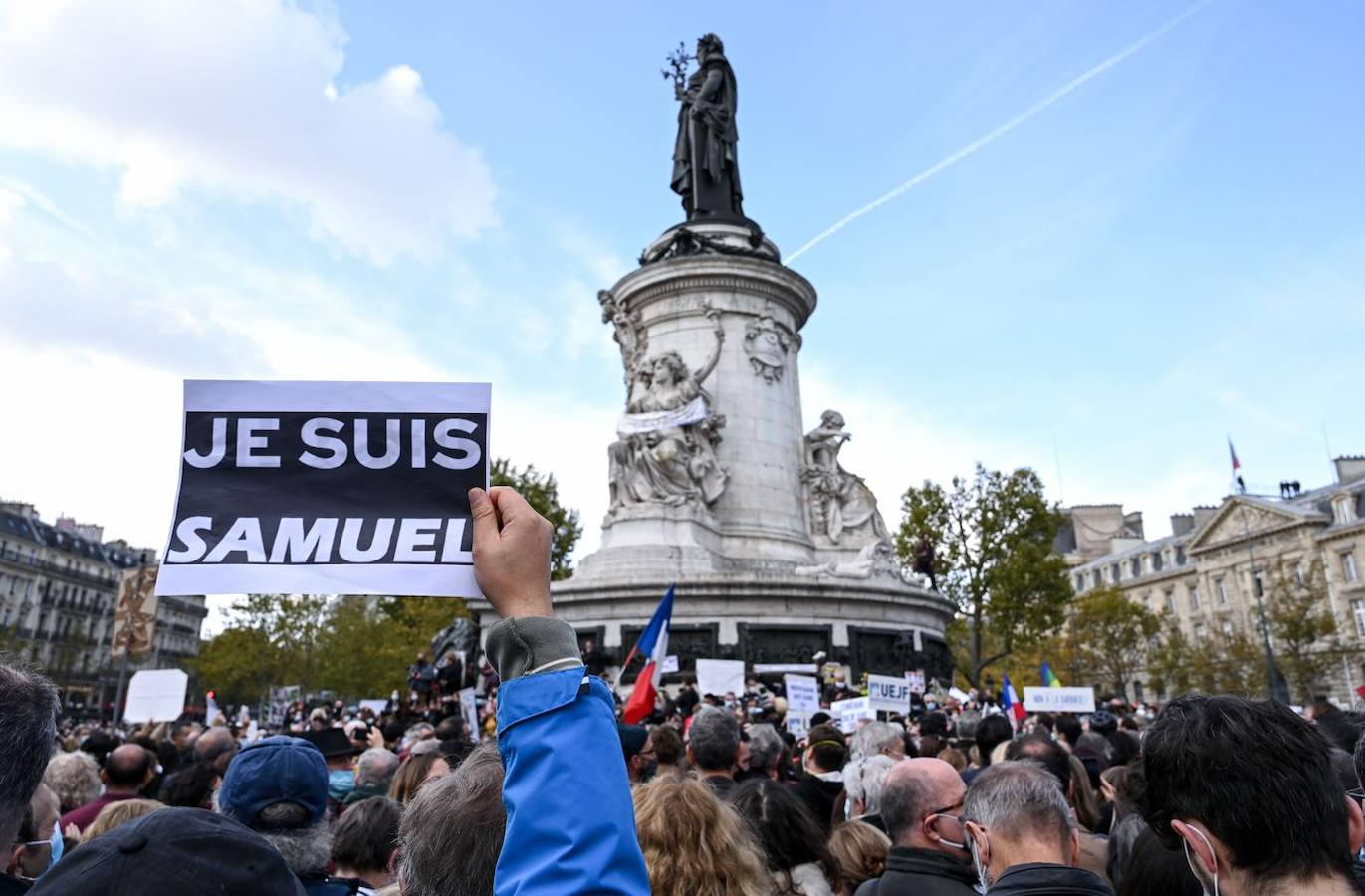 Una persona sostiene un cartel que dice «Soy Samuel» mientras la gente se reúne en la Plaza de la República en París. 