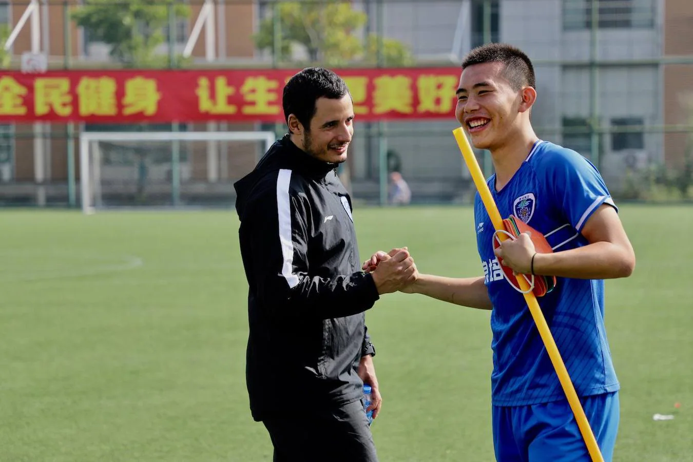 Edu San José, de Barcelona, bromeando con uno de los jugadores chinos durante los entrenamientos. 