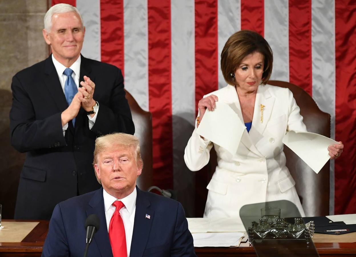 El vicepresidente Mike Pence aplaude a Trump, mientras la presidenta de la Cámara de Representantes, Nancy Pelosi, rompe una copia del discurso del mandatario el 4 de febrero de 2020 en el Capitolio.. 