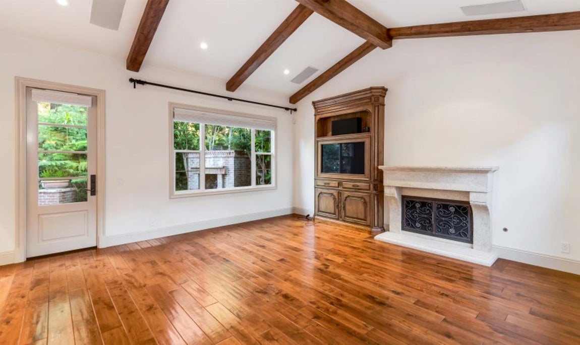 La casa californiana de Kobe Bryant vendida por 2 millones. En el salón principal los techos abovedados y las vigas de madera le dan un toque rústico muy elegante, igual que la chimenea.