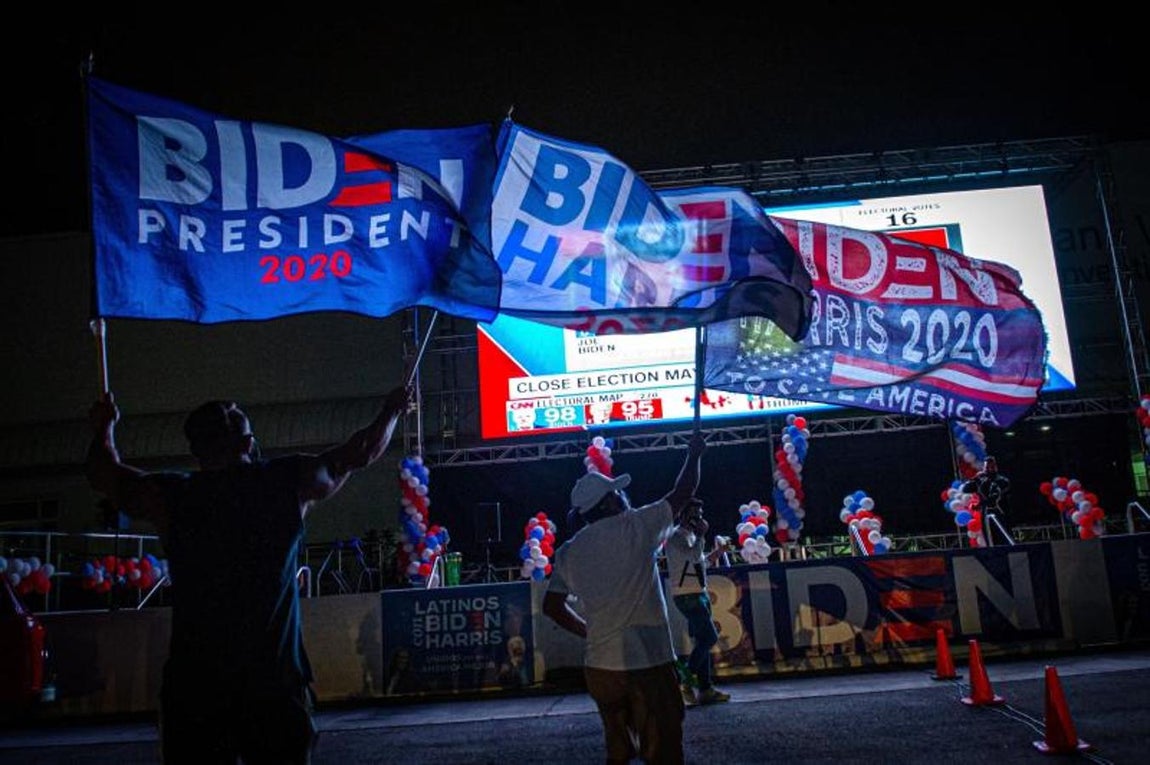 Simpatizantes del candidato demócrata a la presidencia, Joe Biden, ondean banderas y muestran su apoyo en Miami, Florida. 
