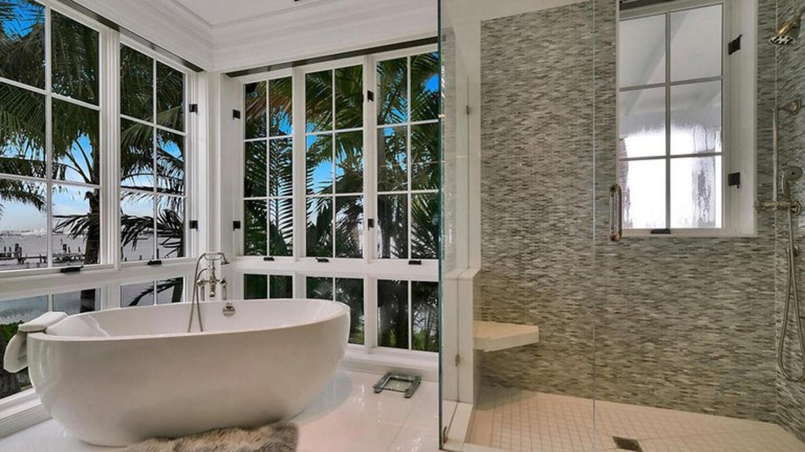 La nueva mansión de Sylvester Stallone en Palm Beach. El baño de la estancia principal cede el protagonismo a los grandes ventanales que rodean la espaciosa bañera y la ducha con mampara de vidrio.