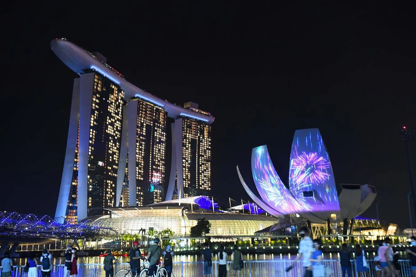 La gente espera para ver el espectáculo de luces y fuegos artificiales en las inmediaciones de la Bahía Marina, en Singapur.. 