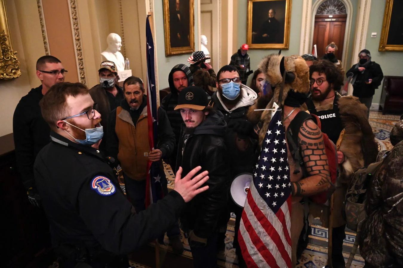 Un agente intenta frenar a los manifestantes, que han logrado entrar al Capitolio. 
