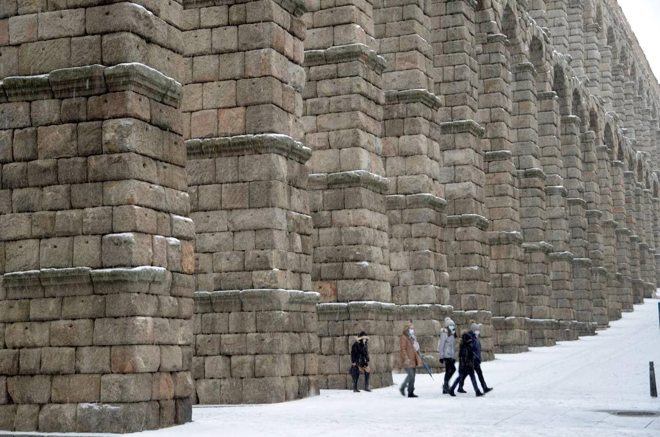 Filomena también se instala en el acueducto de Segovia. Varias personas pasan por debajo de los arcos del Acueducto de Segovia durante una intensa nevada, este viernes, jornada marcada por el paso de la borrasca Filomena