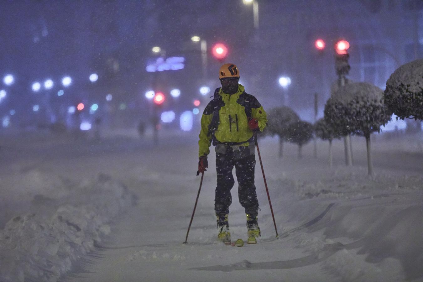 Con esquís en la capital. Muchos ciudadanos han aprovechado la nevada para ponerse los esquís y recorrer las calles de la ciudad. En la imagen, un esquiador cruza el centro de Madrid, rodeado de nieve, el viernes por la noche.