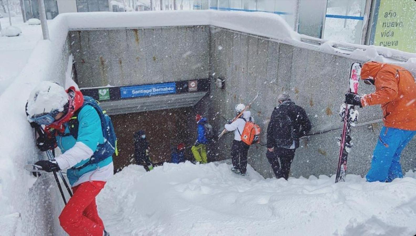 Esquiadores en el Metro. Varias personas equipadas con trajes, esquís y botas entran y salen de la estación de Metro de Santiago Bernabéu. Las escenas de esquiadores deslizándose por la capital se han sucedido a lo largo de la jornada.