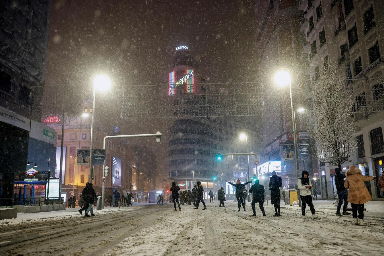 Los madrileños ocupan la Gran Vía para jugar con la nieve y hacerse fotos. 