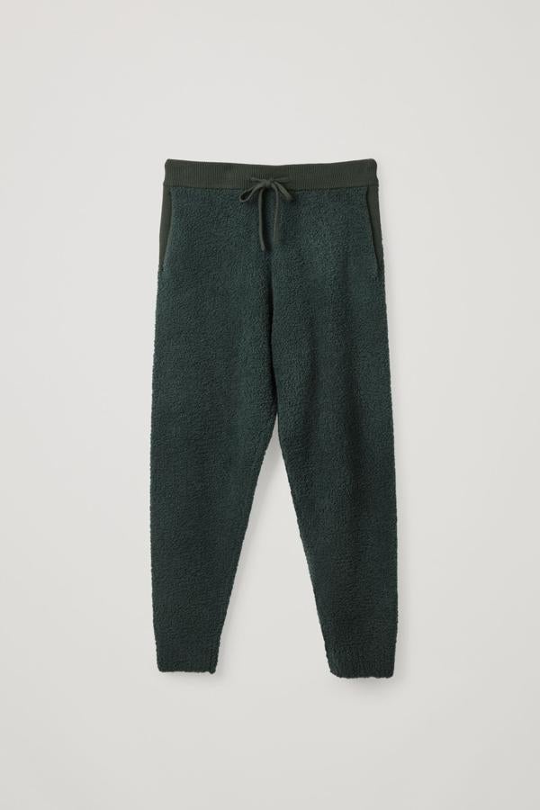 Joggers de lana merino, de COS. Diseñado para looks cómodos y con estilo están hechos con una mezcla de lana merino con efecto peluche Confeccionados con una mezcla de lana merino, estos joggers de peluche son el estilo perfecto para el tiempo libre. Sal a la calle también y combínalos con tus prendas de invierno favoritas. Precio: 99 €.
