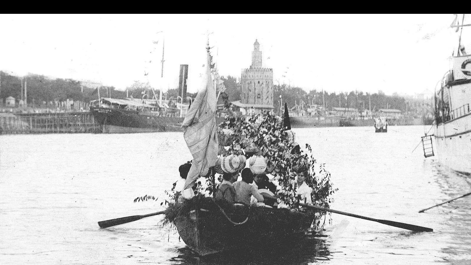 Instantánea de la procesión fluvial de la Vírgen del Carmen de 1917, cuando se cumplía el centenario de la botadura del primer barco de vapor español y sevillano, con la Torre del Oro en último término