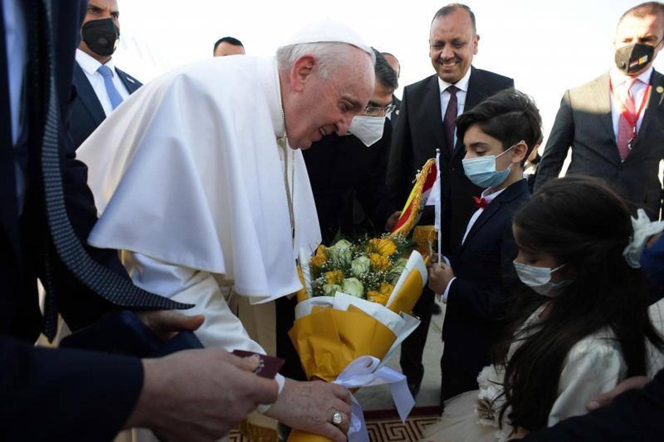 Una imagen proporcionada por los medios de comunicación del Vaticano muestra al Papa Francisco recibiendo un ramo de flores de un niño antes de su reunión con el alto clérigo chiíta iraquí, el Gran Ayatolá Ali al-Sistani en Najaf. 