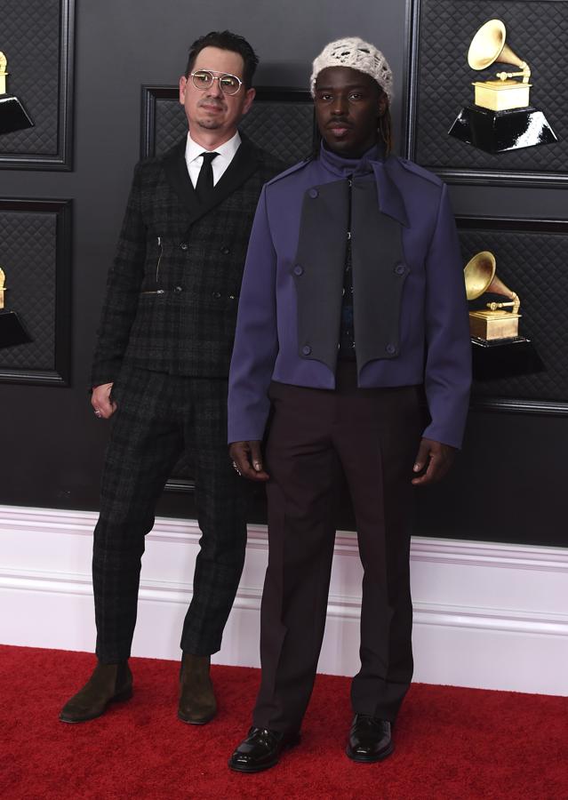 Adrian Quesada y Eric Burton, de Black Pumas - Alfombra roja de los Grammy 2021. Se decantaron por dos diseños cargados de personalidad. Adrian un traje 'slim fit' con estampado de cuadros y Eric un diseño bicolor cuya chaqueta mostraba volúmenes en las solapas y una lazada al cuello.