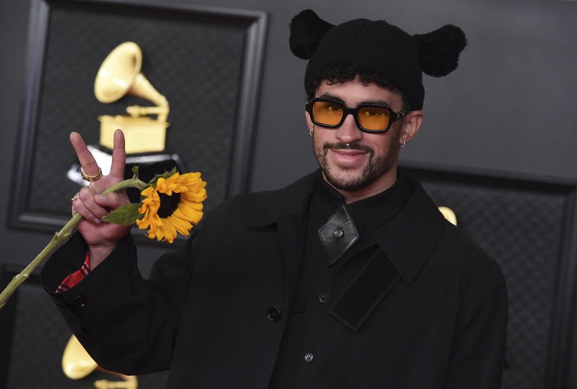 Bad Bunny - Alfombra roja de los Grammy 2021. El cantante de reggaeton lució un 'total look black' de Riccardo Tisci para Burberry compuesto por una falda midi, camisa negra con remates de cuero, botas y un abrigo de corte clásico que aderezó con un gorro con orejas (haciendo un guiño a su nombre artístico) y una margarita XXL.