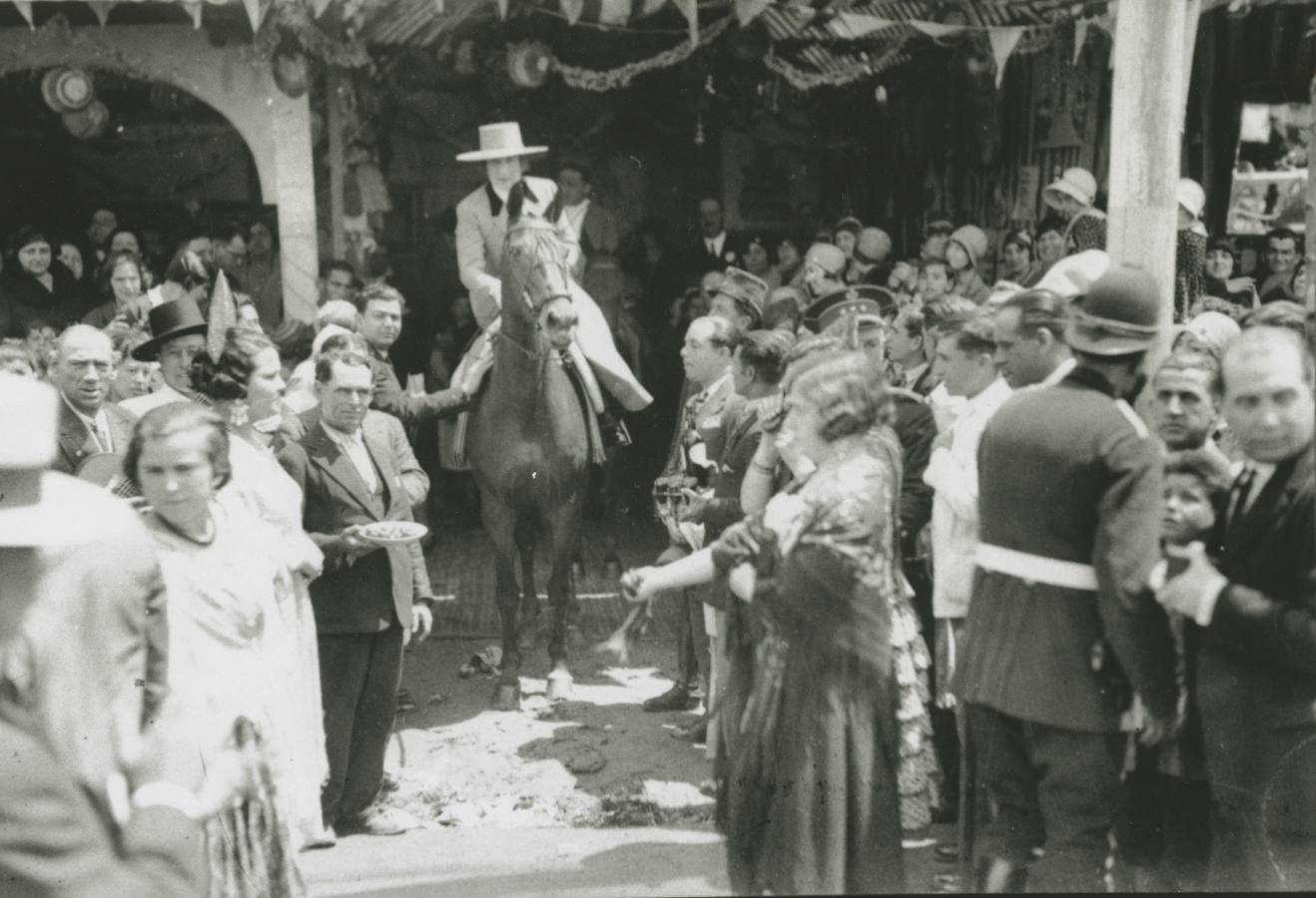 La Reina Victoria Eugenia es aclamada al salir de una caseta de la Feria de Abril de Sevilla de 1930