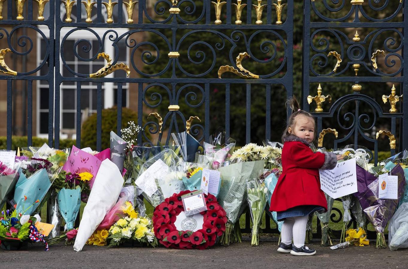 Una niña, frente a las flores en recuerdo de Felipe de Edimburgo. 