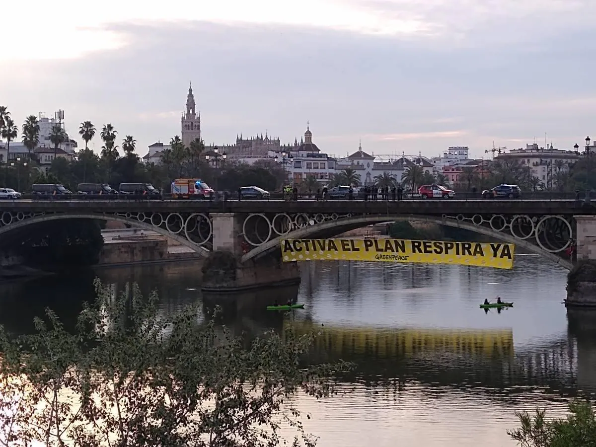 Greenpeace cuelga una enorme pancarta (de lunares) en el puente de Triana en Sevilla
