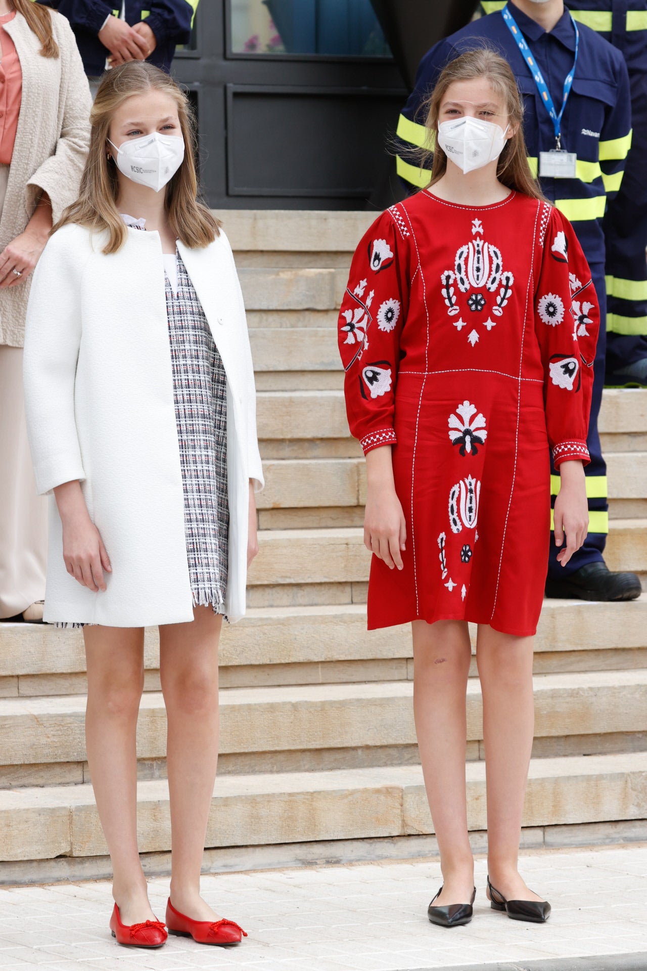 Leonor y Sofía, de 15 y 13 años respectivamente, fueron de corto y zapato plano, en la gama elegida por toda la familia. La princesa, con vestido a cuadros gris, blanco y rojo, de Zara, que acompañó de un abrigo blanco abierto y manoletinas rojas. La infanta, con vestido rojo de aires étnicos, con bordados y mangas abullonadas, de Sfera (ha sido uno de los más buscados de la marca este invierno) y zapatos planos negros sin talón. Ambas, con la melena suelta con un delicado recogido en la parte delantera. Sus vestidos cuestan menos de 30 euros cada uno.. 