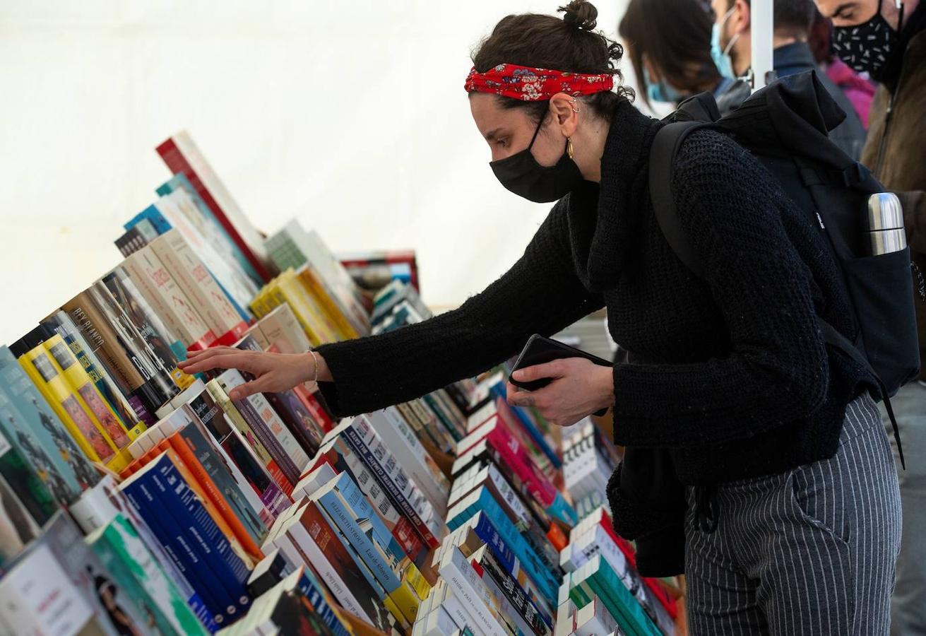 Una persona curiosea entre los libros de una de las paradas de las Ramblas. 