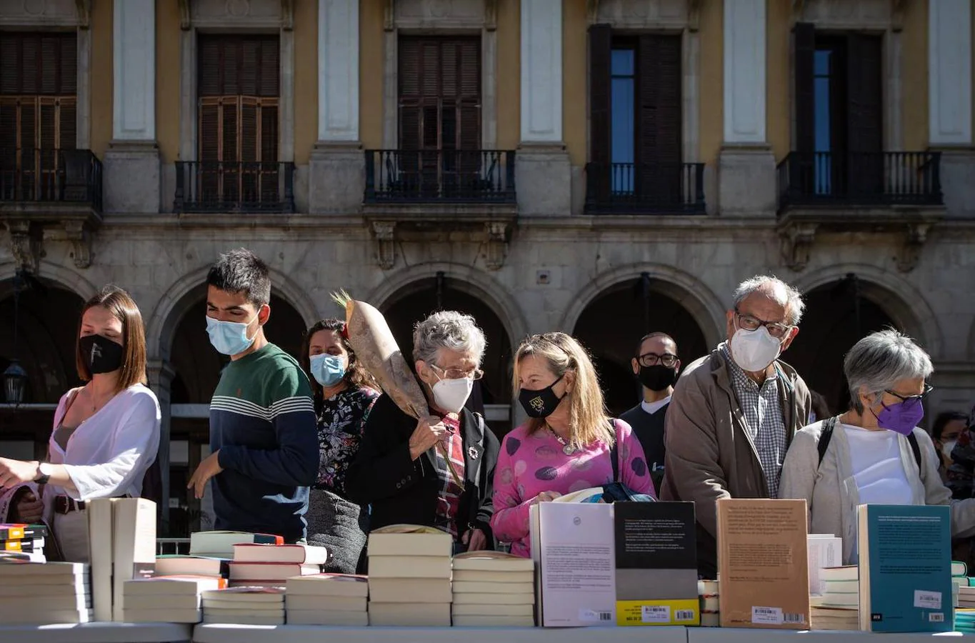 Varias personas curiosean los libros de una de las paradas de las Ramblas de Barcelona este viernes. 