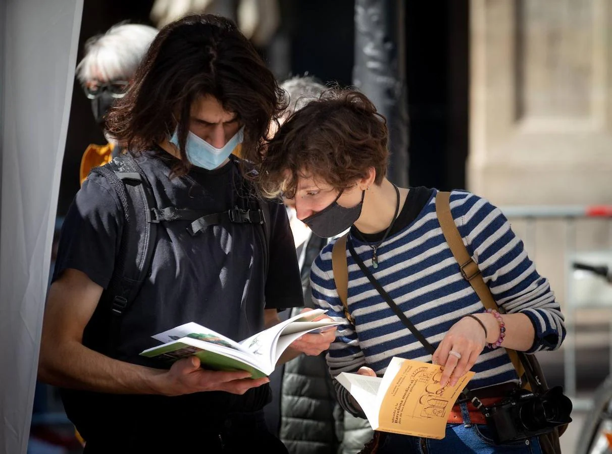 Dos personas ojean libros en una de las paradas de las Ramblas de Barcelona. 