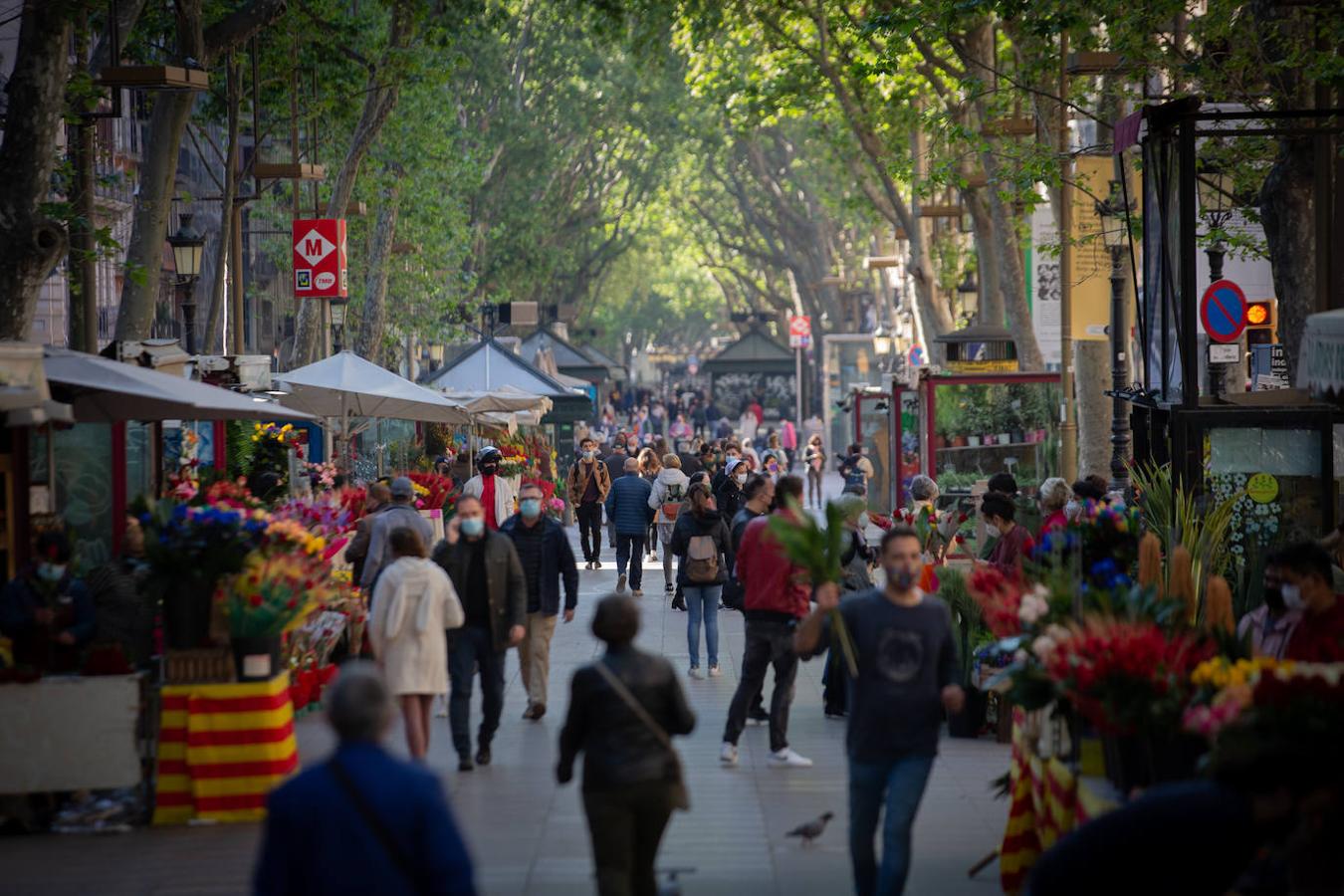 La gente camina por las Ramblas de Barcelona. Por segundo año consecutivo, no se podrá disfrutar de la imagen habitual de las Ramblas repleta de flores y puestos de libros en el Día de Sant Jordi debido a las restricciones por la pandemia de Covid-19. 