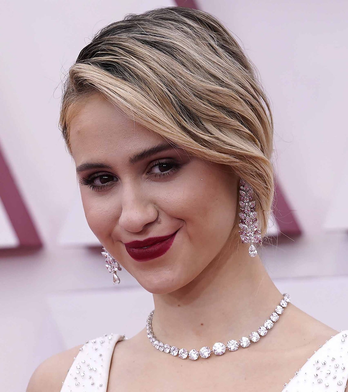 Maria Bakalova en los Oscar 2021. La actriz búlgara ha sido una de las que ha elegido pintar sus labios rojos, dando un toque de color que contrastaba de forma muy bonita con su cabello rubio y su piel nívea. Como peinado, Maria Bakalova, ha optado por un recogido.