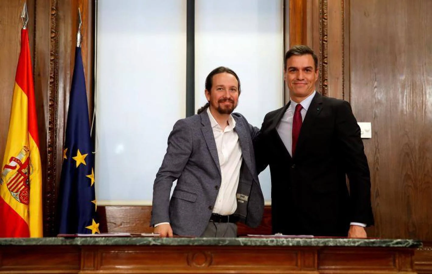 Pedro Sánchez, en el momento de la fotografía como candidato a la investidura, y Pablo Iglesias se abrazan tras firmar su acuerdo de Gobierno el 30 de diciembre de 2019.. 