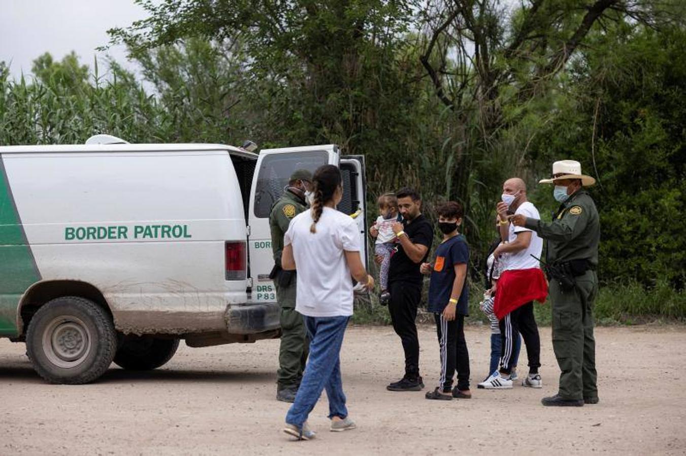 Un grupo de inmigrantes espera ante la furgoneta de la Patrulla Fronteriza de EE.UU.. 