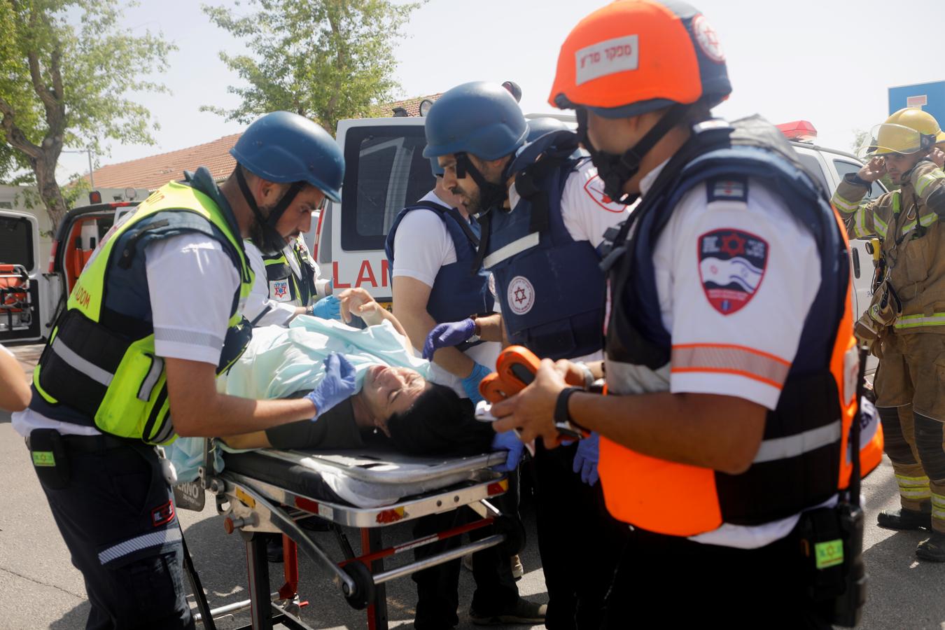 Médicos evacuan a una mujer herida tras el impacto del cohete. 