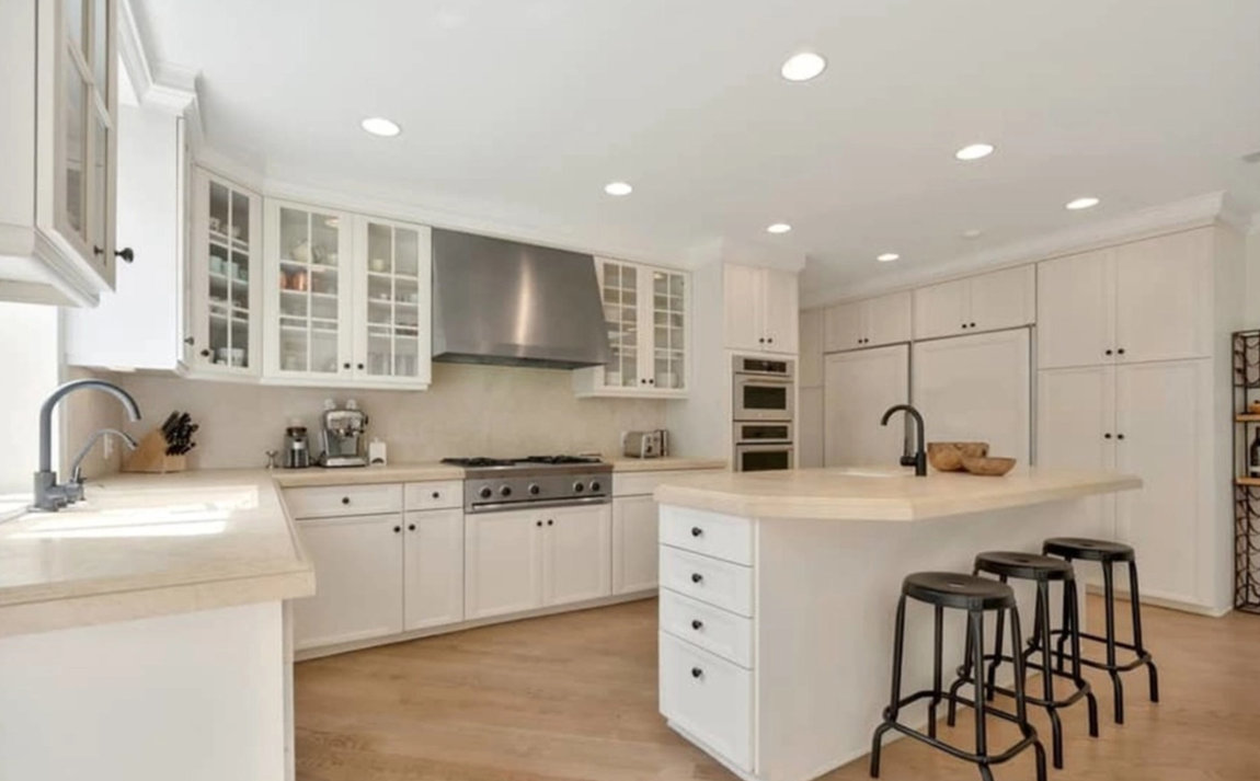 Así es la casa que ha vendido Katy Perry. La cocina tiene gabinetes en color blanco, electrodomésticos de acero inoxidable y una generosa isla con barra de desayuno y espacio extra de almacenaje. Junto a esta hay una pequeña zona de comedor con una mesa redonda con capacidad para cuatro personas.
