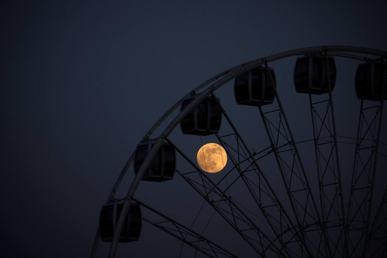 Superluna vista entre las cabinas de una noria en Córdoba. 