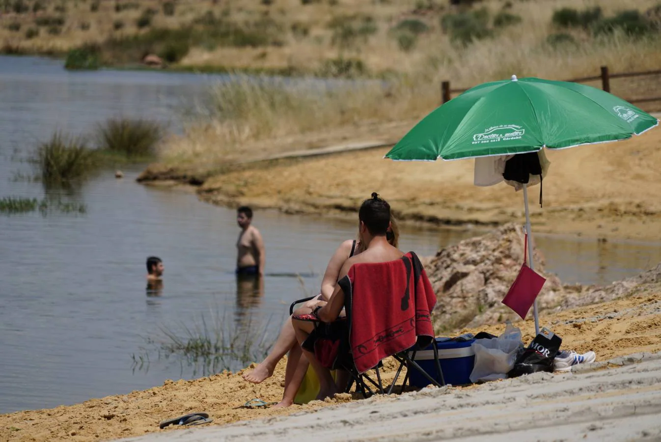 El primer baño en la playa del embalse de La Colada en Córdoba, en imágenes