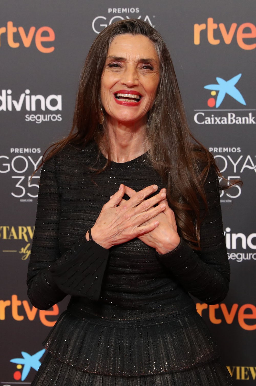 Ángela Molina. Ángela Molina es otra de las famosas que prefiere aceptar su edad y se resiste a teñir su pelo. La actriz, que este año recibió el Goya de Honor, posó en la alfombra roja con sus canas, asomando en su larga melena, tan bella como siempre. Es uno de los mayores ejemplos de belleza natural, a sus 65 años, Ángela Molina rechaza los tratamientos estéticos y prefiere lucir sus arrugas sin ningún tipo de complejo.