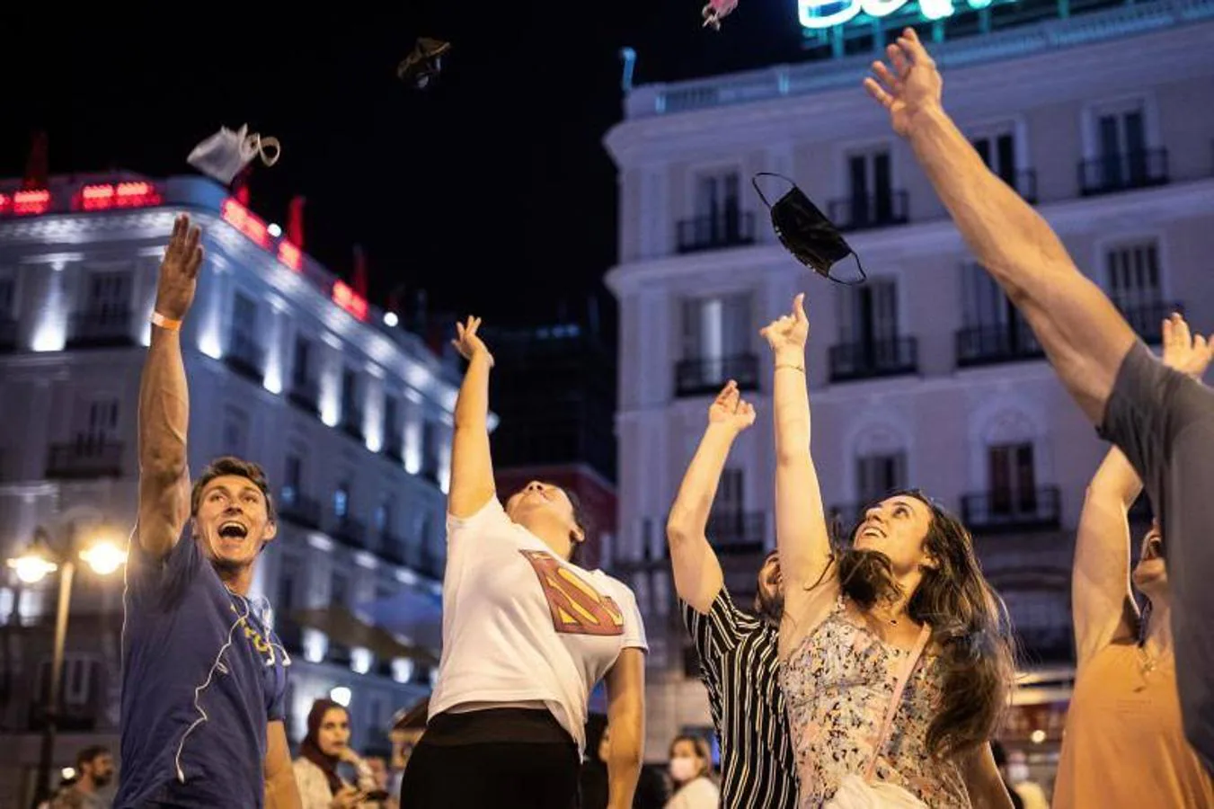 Varias personas celebraron la madrugada de este sábado el fin del uso obligatorio de la mascarilla en espacios abiertos en la Puerta del Sol, en Madrid. 