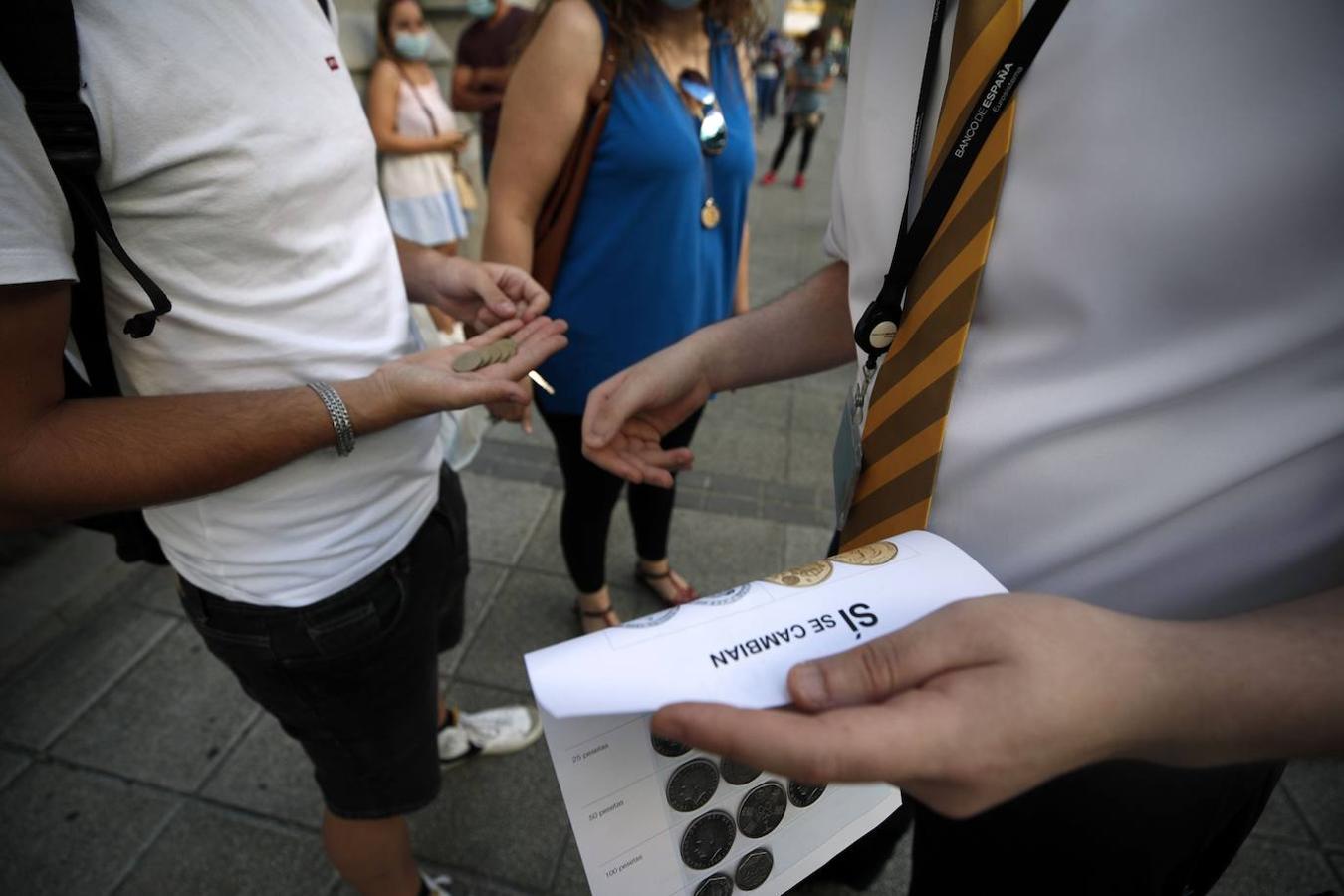 Un funcionario informa sobre el cambio de pesetas y euros a la gente que hace cola en la sede del Banco de España de Madrid. 