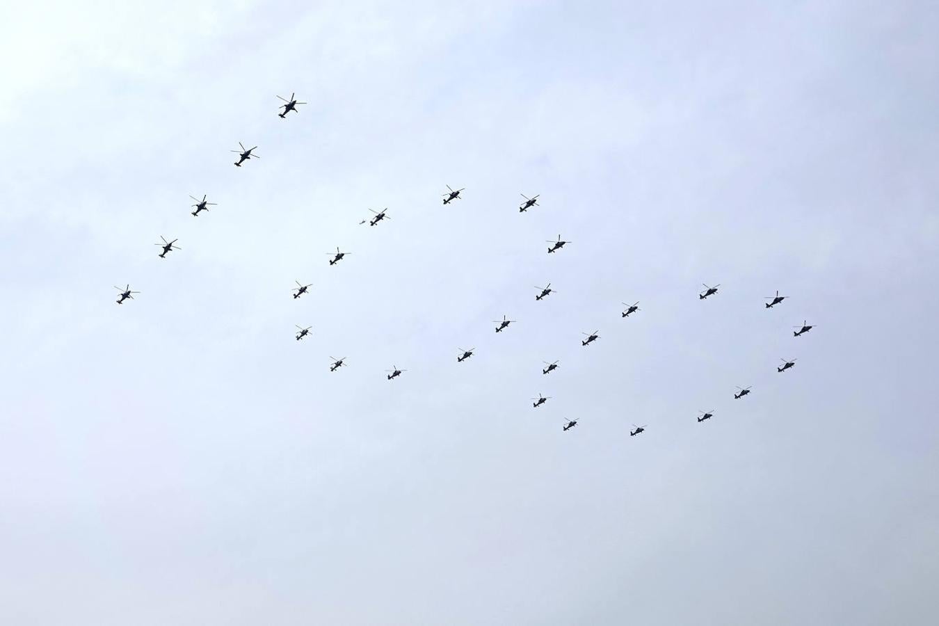 Helicópteros militares chinos vuelan en formación de '100' durante la ceremonia por el centenario del Partido Comunista chino. 