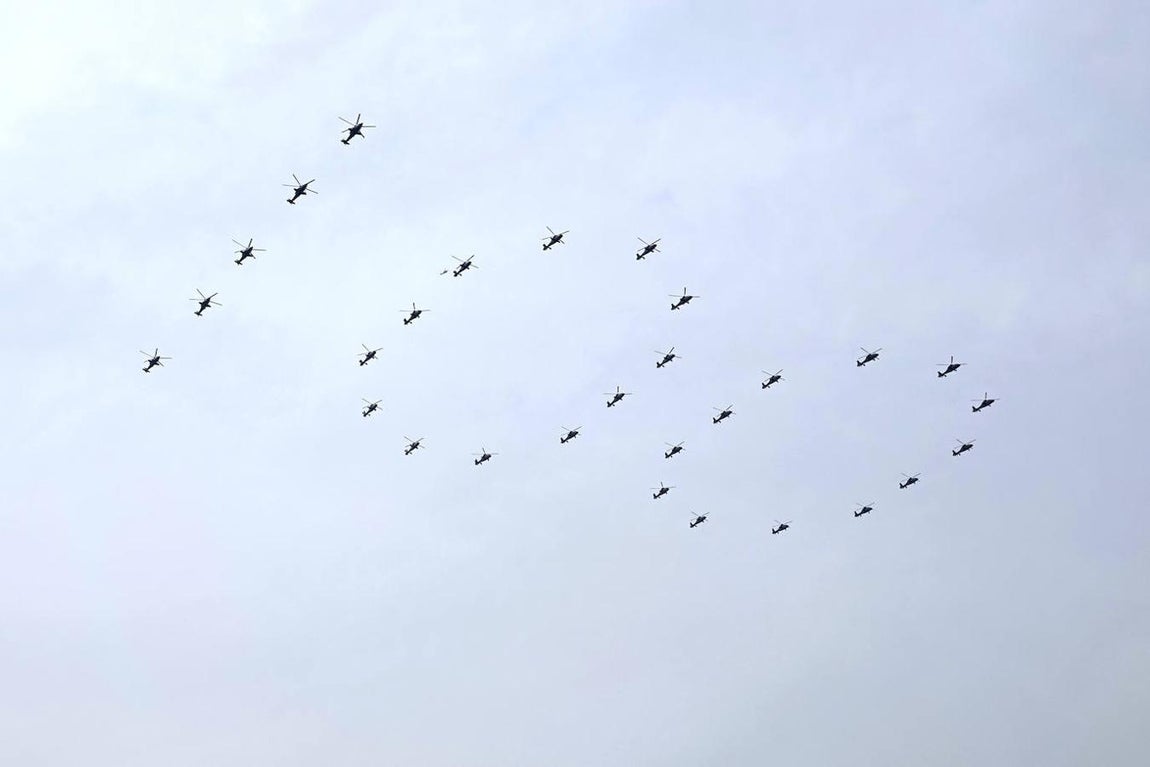 Helicópteros militares chinos vuelan en formación de '100' durante la ceremonia por el centenario del Partido Comunista chino. 