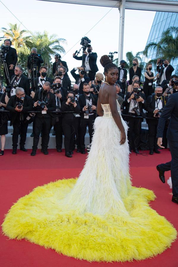 Jodie Turner-Smith. Con un llamativo vestido con corpiño y cola en amarillo y blanco.